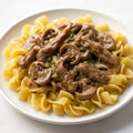 Beef Stroganoff - classic tender beef strips in a creamy mushroom sauce over egg noodles recipe created by pantribot using RolTak AI